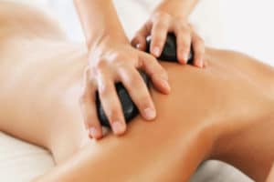 South Africa, Cape Town, Woman relaxing while getting stone massage